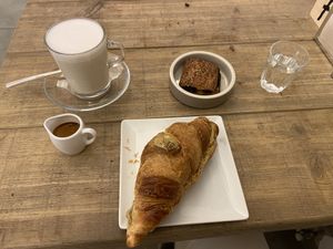 Pistachio croissant, pain au chocolat, caffè macchiato  at UNO Caffé Olistico in Bologna