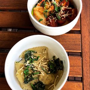 Cashew-cheese filled ravioli with white cashew-cream sauce and cherry tomato sauce at Eat Plants in Toronto