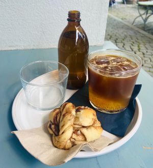 Vegan cinnamon roll, espresso tonic and a bottle of water  at SUEDHANG in Tubingen
