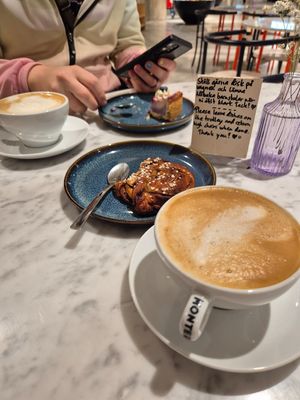 Two lattes, sweet pastry and blueberry cheesecake at Kafé Plattan in Stockholm