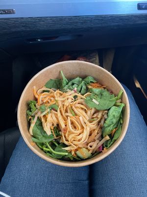Half full bowl with a pad Thai noodles. You can see there is very little peanut dressing on the noodles. Below the noodles is plain spinach with no sauce or dressing.   at Mudsharks Coffee Bar in Courtenay