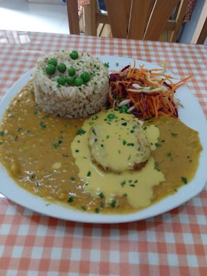 Split pea stew, rice, salad, protein with huancaína sauce at Good Karma in Lima