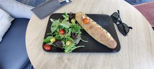 sandwich vegan servi avec de la salade et une vue sur la plage at Bar La Passerelle in Saint-malo