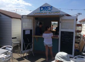 Exterior of hut and outside seating at Dre's Caribbean Kitchen in Herne Bay