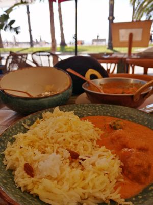 Arroz con azafrán y pasas con albóndigas de carne vegetal y patatas en sala de tomate. at Cinnamon in Sitges