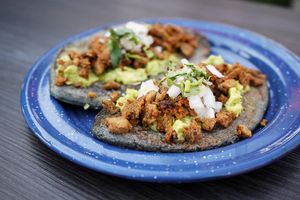 "Tlacoyitos"
An Ancient dish from México named "tlacoyo" (blue corn with seasoned beans) with seitan based beef, vegan chorizo and guacamole! at Version Vegana in San Andres Cholula