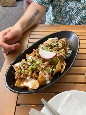Chilaquiles for sharing - fried corn tortillas with a lot of delicious toppings. at Taqueria La Lupe in Sevilla