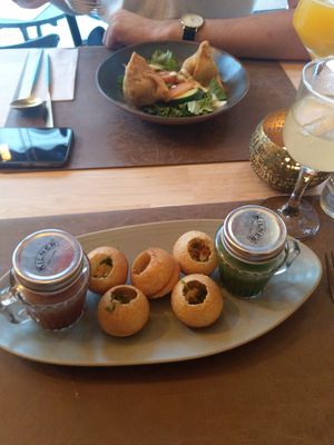 Pani puri, described on the menu as India's favourite street food: puffed dough balls filled with seasoned mashed potatoes and vermicelli served with a dash of tamarind and cumin m at Garlic n Greens in Bruges