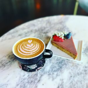 Seasonal St. Valentine Latte (raspberry mocha) made with oat milk. A gluten free Berry Tart topped with fresh berries.  at Cyth & Co in Oakland Park