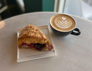 Latte made with oat milk & housemade lavender syrup. Raspberry lemon scone made with fresh raspberries & lemons. at Cyth & Co in Oakland Park