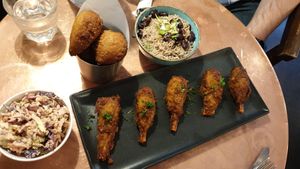 Rum chicken wings, coleslaw, rice and peas, sweet pastry at Jam Delish in North London