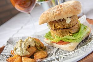 La nostra vegan burguer - De soja, carbassa i curry amb tomàquet, enciam i formatge vegà amb pa de xapata de vidres i patates braves. at Mitica la Vella in Terrassa