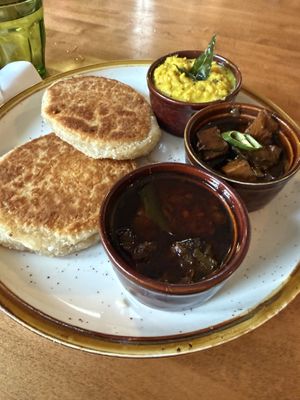 Pol Roti plus small bowls of: Parippu, Black Pork Curry, and Jaggery Beef Curry  at Mirisata in Portland
