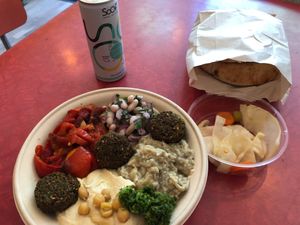 Mezze bowl: hummus, white bean salad, baba ganoush, red bell pepper, falafels and a spicy green condiment. Vegetables on the side and home-baked pita.   at Levantini in Maastricht