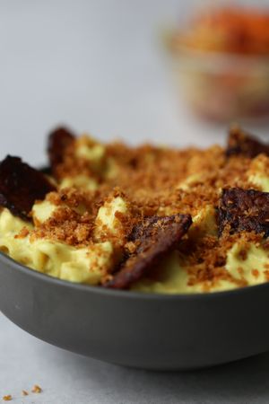 Vegan mac and cheese topped with tempeh bacon and crunchy breadcrumbs served with a tangy slaw.  at Foodbae in Kuala Lumpur