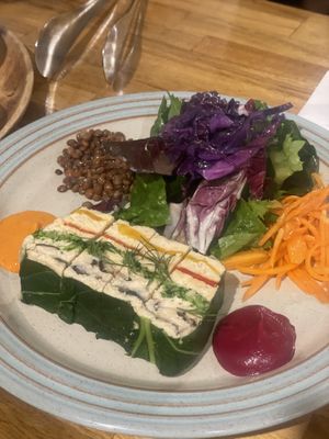 Terrine stuffed with soybean hummus & layered vegetables. Comes with salad & sauce on side  at local EAT in Seoul