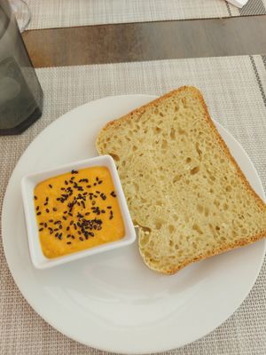 Aperitivo de la casa hummus de piento dulce y pan casero at L'Atelier in Mecina Fondales