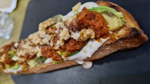 Toast with avocado, tahini, walnuts and sun-dried tomatoes. at Santa y Pura in Madrid
