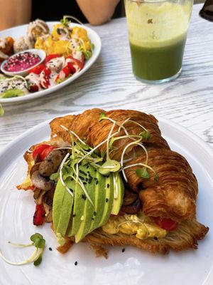 All-day breakfast croissant with tofu scram, roasted tomatoes and mushrooms, avocado + micro greens.   at Wildsprout in Western Cape