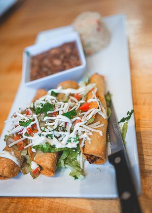 Vegan Potato Flautas meal (three potato roll crispy tacos topped with fresh lettuce, pico de Gallo, vegan cheese, vegan sour cream. served with vegan rice & refried beans) at Casa Azul Taqueria in Providence