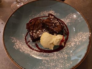 Warm chocolate brownie with clotted cream and raspberry coulis. at Harbour Lights in Paignton