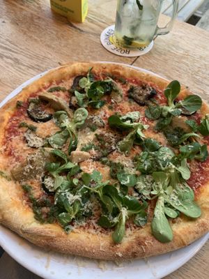 ‘The garden’ tomato sauce, homemade cheese, grilled zucchini, artichoke, lamb lettuce, homemade Parmesan and salsa verde  at Vegan Pizza Bar in Rotterdam