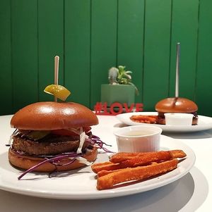 Vegan burger with Russian-made vegetable cutlet, homemade cashew mozzarella, barbecue sauce, salad. Served with sweet potato, chickpea-mustard sauce and pickled cucumber. at I Love You - Я люблю тебя in Krasnodar