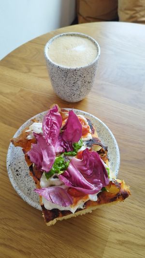 Oat latte and focaccia with tomatoes and pesto at Eter Vegan Bakery in Warsaw