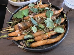 Wood-roasted carrots served with capers, chopped olives, and nasturtium leaves  at Fiorella in San Francisco