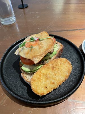 Vegan avocado toast with added sunny side up fried vegan egg and hash brown  at The Little Poet in Hobart