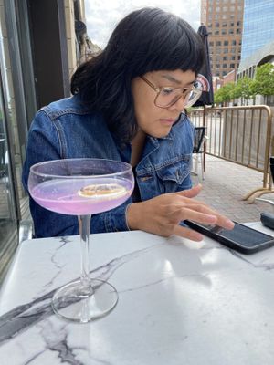 Reading the digital menu with side of cocktail at Astoria Bistro Botanique in Gatineau