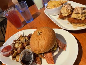 Campfire Burger with breakfast potatoes. Chicken Biscuits behind with Cheesy Fries  at Brunch Bird in Austin