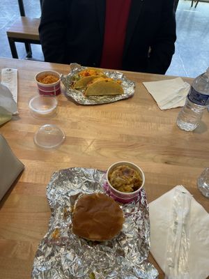 Deep Sea Fish sandwich and truffle potatoes in the foreground; Spanish Sea Shell tacos and rice in the background.  at Deep Sea Vegan in Nashville