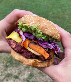 The Red Dwarf Burger- Beet and lentil patty, carrot bacon, purple cabbage, smashed avocado, Magic Sauce and cheese (vegan or dairy). GF bun available.  at Spacecat V-stro in Ferndale