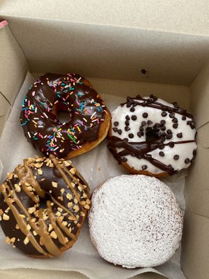 Clockwise from top left: chocolate frosted with sprinkles, vanilla frosted with chocolate chips, raspberry jam (filled), Snickers  at Donut Run in Washington