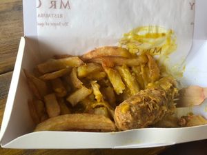 Bartered vegan sausage (half-eaten), chips and curry sauce.   at Mr Chippy in York