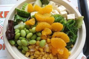 Create your own fusion bowl, with mixed salad greens, oranges, corn, cucumbers, seaweed salad, edamame, and tofu with vegan yum yum sauce. at Poke Fusion in Fort Myers