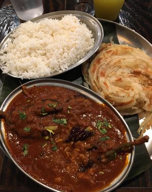 A delightful meal consisting of Kaara Kolambu (spicy southern curry with eggplant) and Oor Style Parota (a pair of flaky, layered, southern style bread). at Kumar's Minneapolis in Apple Valley
