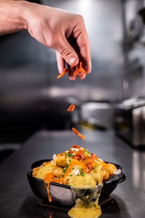 Dirty Hash Browns - Our famous Mini Hash Browns topped with an indulgent vegan cheese sauce, spring onions, chives and vegan bacon! at The Hogless Roast in East London