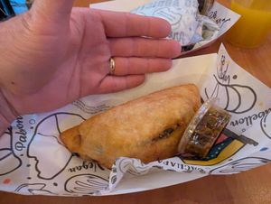 Empanada, with hand for scale at Arempas in Salt Lake City