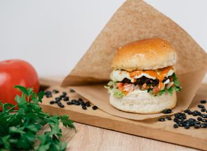 Vegan burger with a black bean patty, homemade brioche bun, vegan mayonnaise, tomato salsa, vegan homemade cheddar sauce, green salad. at New Wave Burgers in Sofia