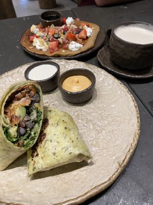 Breakfast burrito (vegan?) with vegetarian ricotta pancake behind at Honest Greens - Born in Barcelona