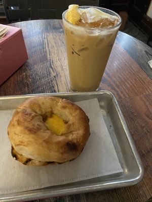 Pistachio latte and vegan breakfast sandwich (sausage, cheese, egg, pepper jelly, bialy)  at Coat Check Coffee in Indianapolis