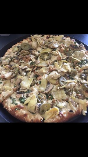 Create your own pizza with Alfredo sauce artichoke hearts, mushrooms, jalapeños and spinach. at Vegan Korner in Grand Terrace