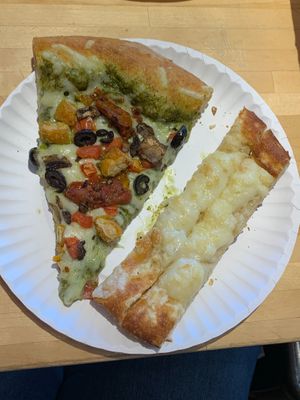 Slice of vegan pesto margherita pizza and a single veganstix topperstix

 at Toppers Pizza in Sioux Falls