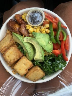 plantains, tofu, avocado, corn, peppers over jollof rice and sautéed kale  at ākra Eatery & Juice Bar in Worcester