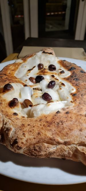 Filled pizza with endives, olives, and capers. at Osteria Casa Pepe in Trieste
