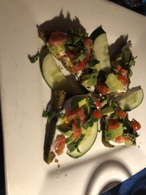 Raw avocado Bruschetta - home made raw coconut bread, house made raw Ali oil, tomato, basil, olives 
(No olives)   at Caravan of Dreams in New York City
