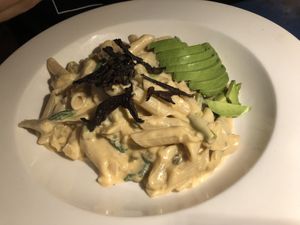 Cashews lemon pasta (gluten free) - shiitake bacon, served with gluten free pasta in a smoky cashew lemon cream. Finished with sliced avocado   at Caravan of Dreams in New York City