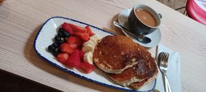 Vegan and gluten free Banana pancakes with maple syrup and fresh fruits at Cafe U in Kelso